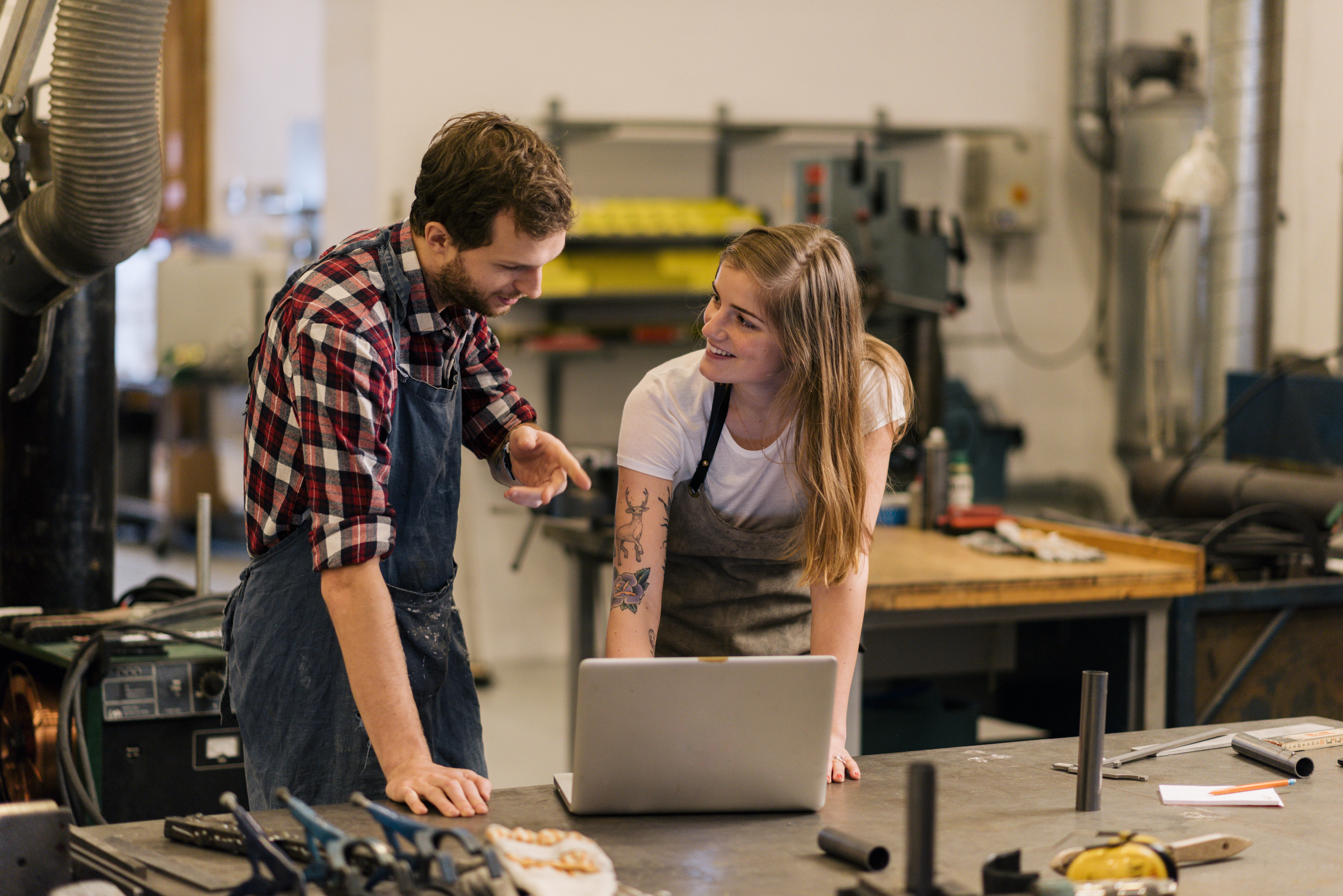 Mann og dame diskuterer ved arbeidsbenken