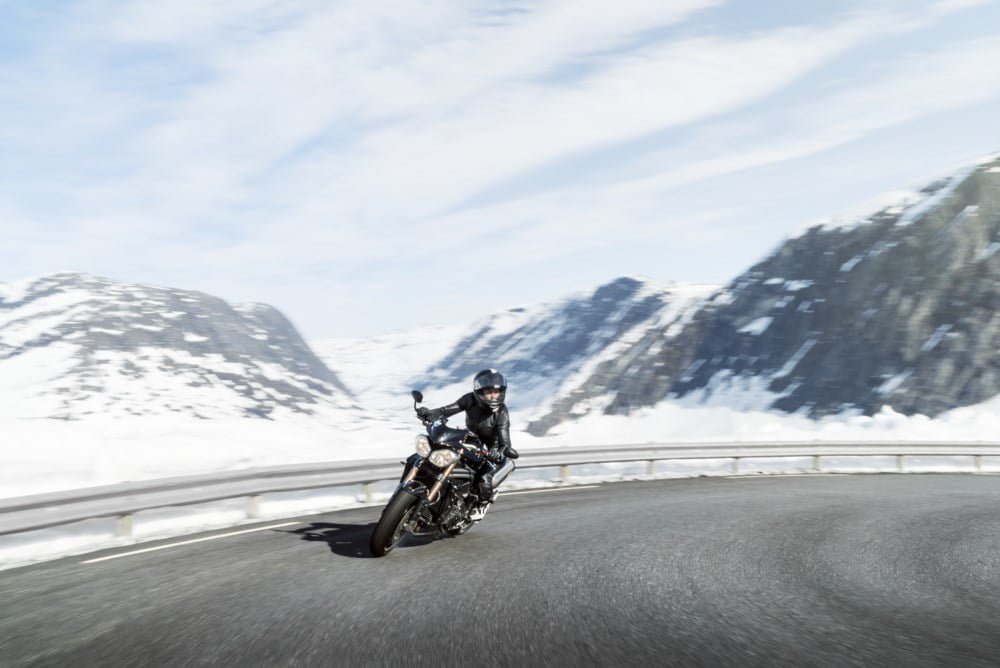 Kvinne på motorsykkel i vinterlandskap Kvinne på motorsykkel i vinterlandskap